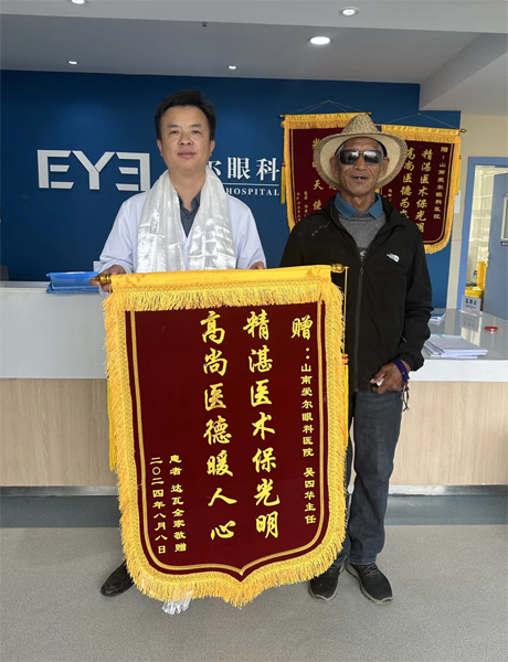 達(dá)瓦老人向吳四華（左）贈送錦旗。受訪者供圖