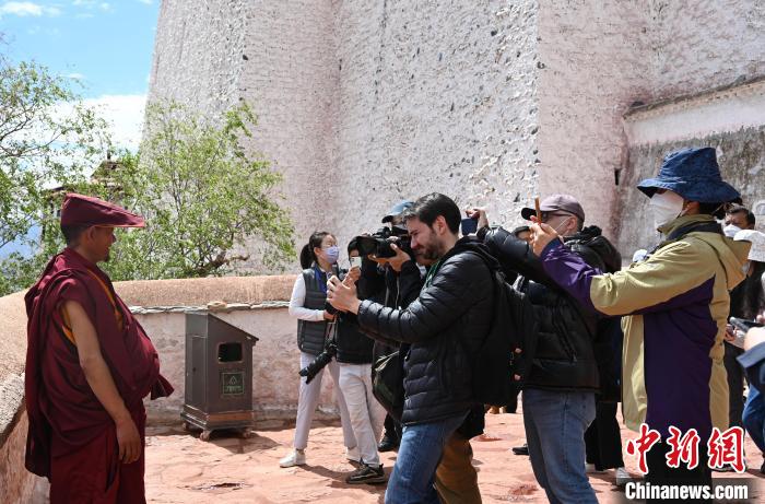 圖為中外媒體拍攝朝拜布達(dá)拉宮的僧人?！≮w朗 攝