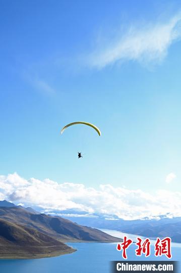 圖為在羊卓雍錯(cuò)，游客體驗(yàn)高空滑翔?！≮w朗 攝