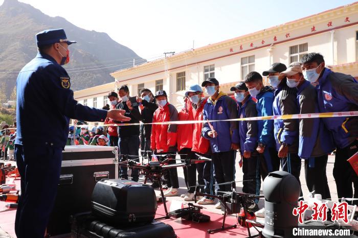 圖為消防指戰(zhàn)員為學(xué)生講解、演示先進救援裝備?！≮w琳 攝