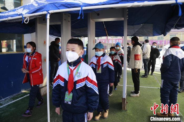 圖為學(xué)生測(cè)量體溫后進(jìn)入校園?！●R銘言 攝