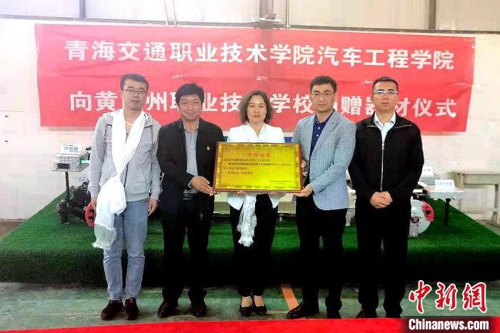 圖為李富香(中)代表學(xué)校為州縣技校捐贈(zèng)器材。(資料圖) 青海省教育廳供圖