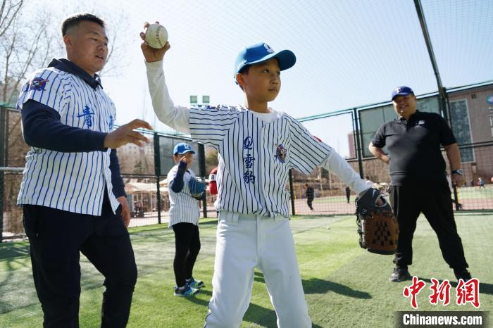 圖為教練指導小棒球手擲球技術?！●R銘言 攝