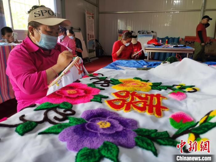 圖為婦女制作青繡?！?zhí)砀?攝
