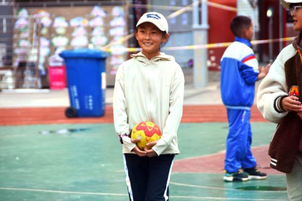 在高原上教孩子們打手球，“慢慢兒來，甭著急！”