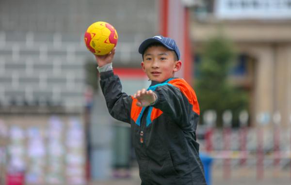 在高原上教孩子們打手球，“慢慢兒來，甭著急！”