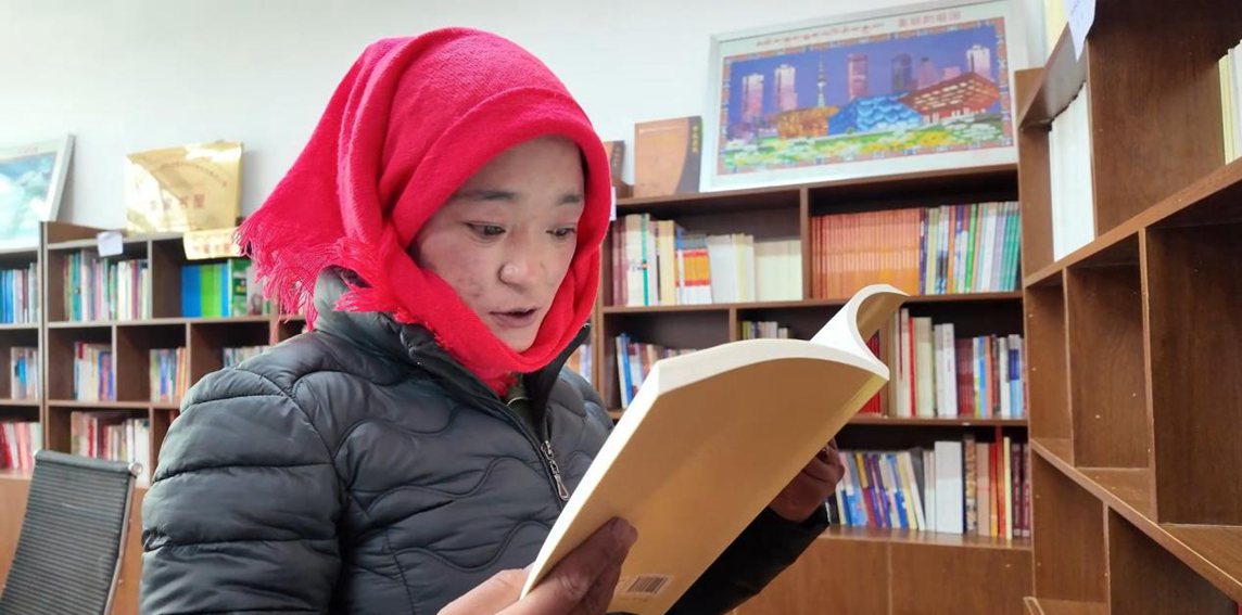 一名婦女正在認(rèn)真閱讀書(shū)籍。申扎縣融媒體中心供圖