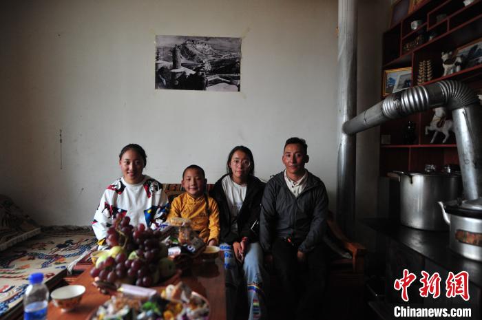 圖為8月12日，2018年7月從距那曲市色尼區(qū)城區(qū)那曲鎮(zhèn)90千米外的古露鎮(zhèn)當(dāng)桑村搬遷至城區(qū)的旦增(右一)與家人在80多平方米的新家合影(資料圖)。　張偉 攝