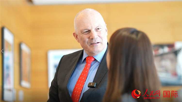 瑞士駐華大使白瑞誼介紹使館內(nèi)陳列的照片。人民網(wǎng) 彭昱凱攝