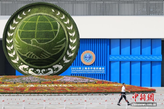 8月31日，天津，一名工作人員從2025年上海合作組織峰會主會場外的景觀花壇旁經(jīng)過。當(dāng)日，2025年上海合作組織峰會在天津舉行。<a target='_blank' href='/'><p  align=