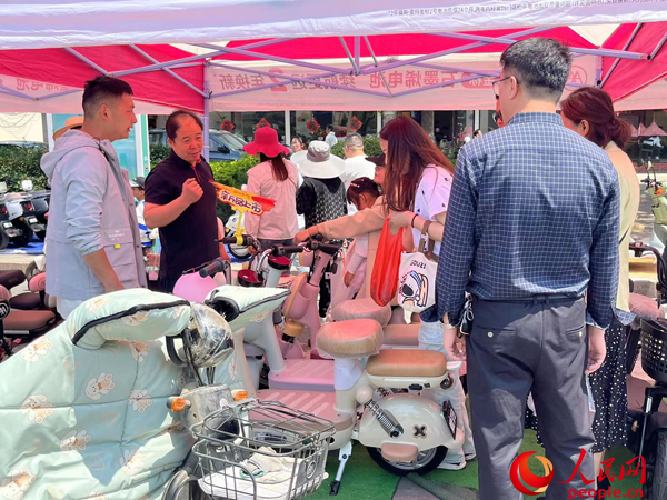 某電動自行車品牌工作人員向消費者介紹以舊換新相關(guān)情況。人民網(wǎng)記者 杜燕飛攝