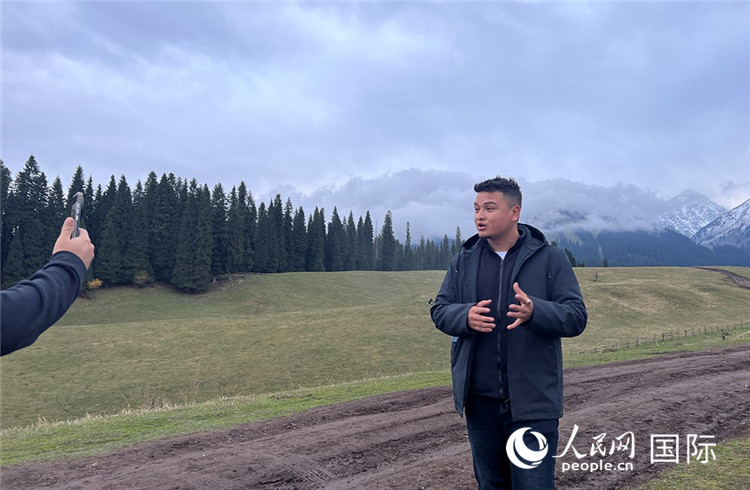 在庫爾德寧，吾買爾江被雪山美景震撼，即興錄制了短視頻作品。人民網(wǎng)記者曾書柔攝