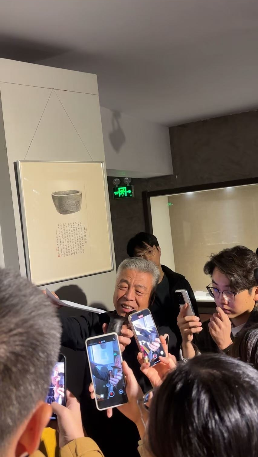 黑陶邢文化博物館館長邢葆東展示兩張相疊的A4紙，向記者解釋此為杯口的厚度。