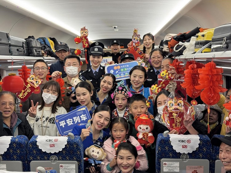 春節(jié)期間，在中老鐵路磨萬（磨丁—萬象）段，鐵路客運員工與乘客合影留念。李加勇攝