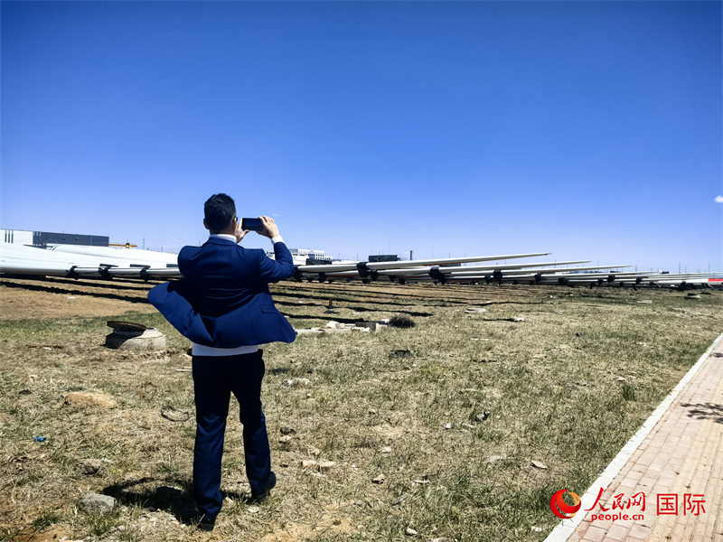 外媒記者拍攝廠房外的風(fēng)力渦輪發(fā)電機(jī)的巨型漿葉。人民網(wǎng) 楊春燕攝