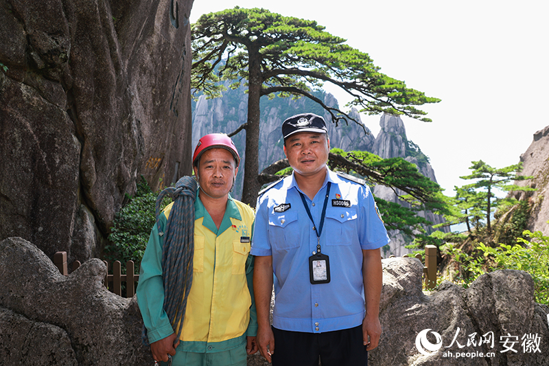 全國(guó)道德模范李培生（左）和胡曉春在迎客松前合影。人民網(wǎng)記者 張俊攝