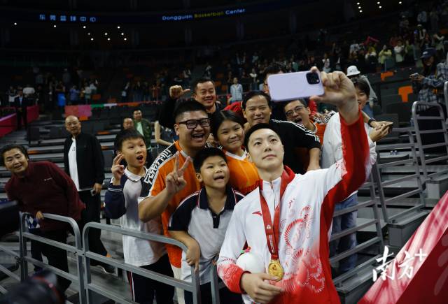 11月12日，十五運(yùn)會(huì)男籃成年組決賽，廣東隊(duì)獲得冠軍后，胡明軒與球迷們合影留念。張由瓊 攝