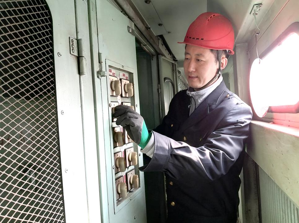 韓文盛認(rèn)真檢查低壓柜。