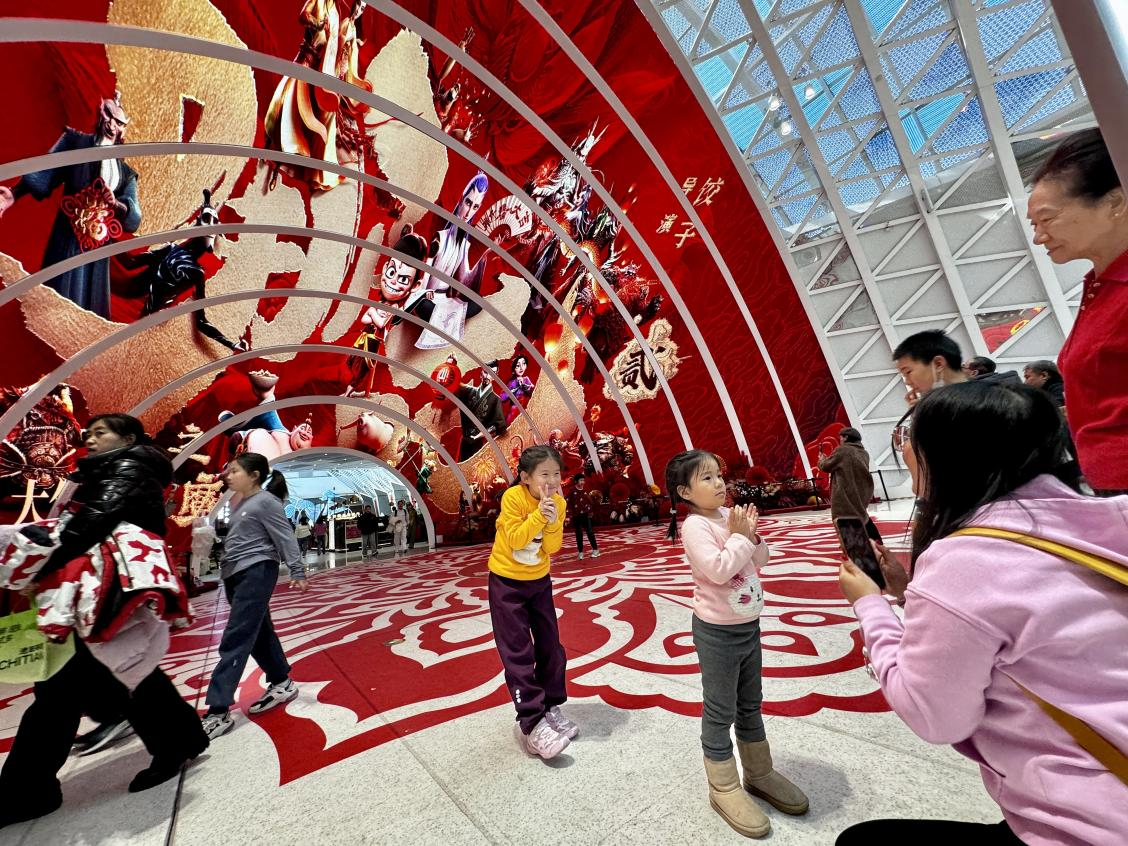 乙巳蛇年春節(jié)期間，影迷在《哪吒之魔童鬧海》巨幅海報前拍照打卡。