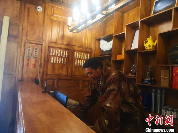 圖為桑杰才讓用電腦處理財務?！∈缝o靜 攝