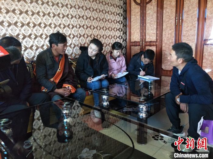 圖為調(diào)查組工作人員正在入戶調(diào)查?！∑钤鲚?攝