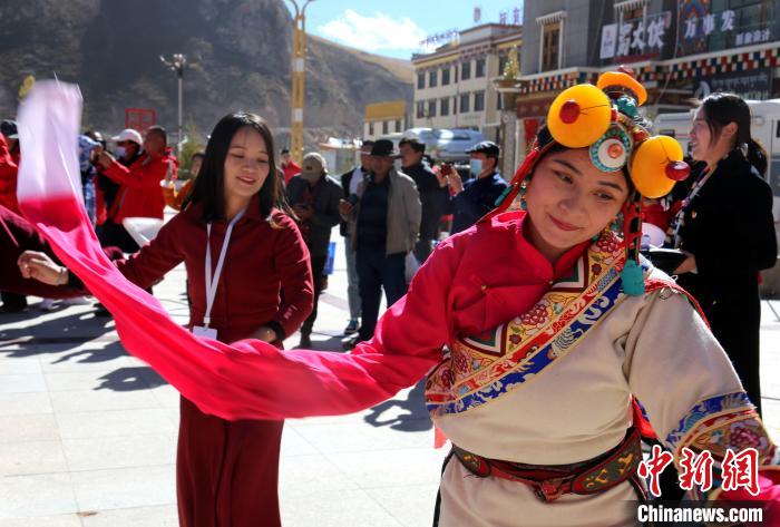 圖為中外記者向當?shù)孛癖妼W(xué)習(xí)民族歌舞文化?！?zhí)砀?攝