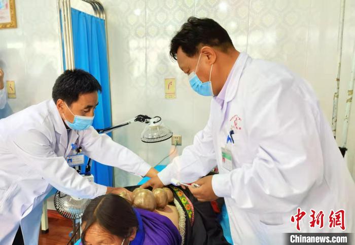 圖為看照加手把手帶徒弟加老(左一)進行拔罐療法?！堟?攝