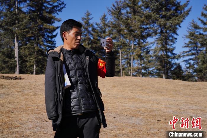 圖為桑杰加進(jìn)行巡查并拍照記錄。　馬銘言 攝