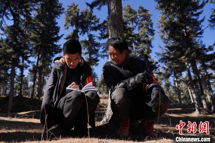 圖為桑杰加(左)和同事記錄巡查結(jié)果?！●R銘言 攝