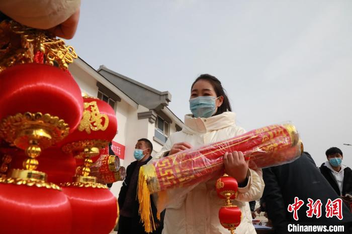 27日，蘭州新區(qū)為舟曲避險搬遷移民送“春節(jié)包”，楊周馬草前往領(lǐng)取，紅色寓意來年的日子紅紅火火?！∥航ㄜ?攝