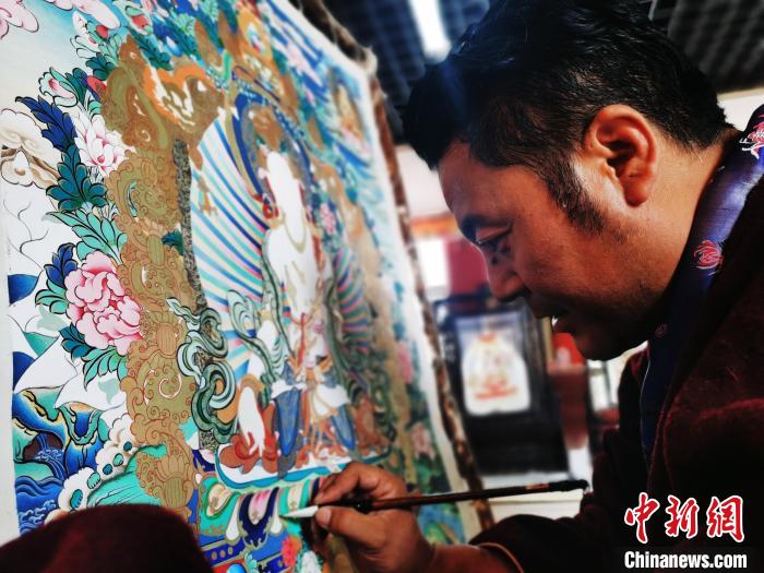 圖為久美尖措創(chuàng)作唐卡?！?zhí)砀?攝