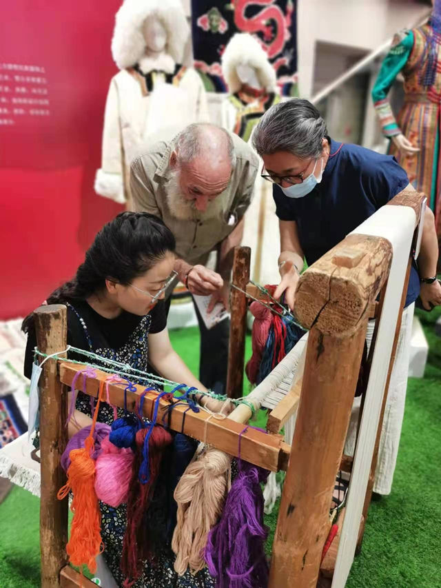 楊永良的學生在展會上向客商介紹加牙藏毯編織技藝。受訪者供圖