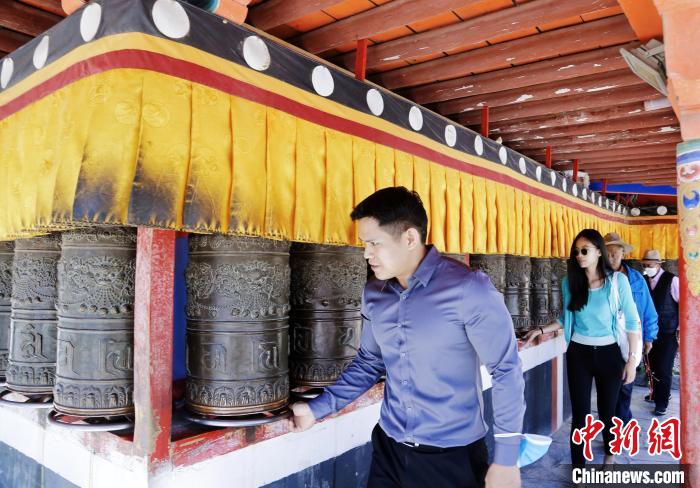 圖為外籍嘉賓體驗(yàn)藏族傳統(tǒng)轉(zhuǎn)經(jīng)筒?！●R銘言 攝