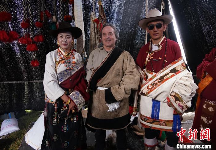 圖為一名外籍?dāng)z影師(中)身穿藏服和藏族民眾合影留念。　馬銘言 攝