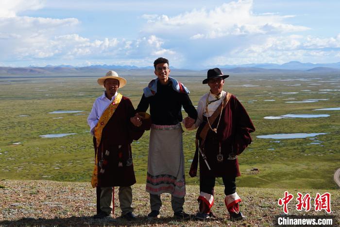 圖為一名留學(xué)生身穿自己國(guó)家的服飾和藏族民眾合影留念?！●R銘言 攝