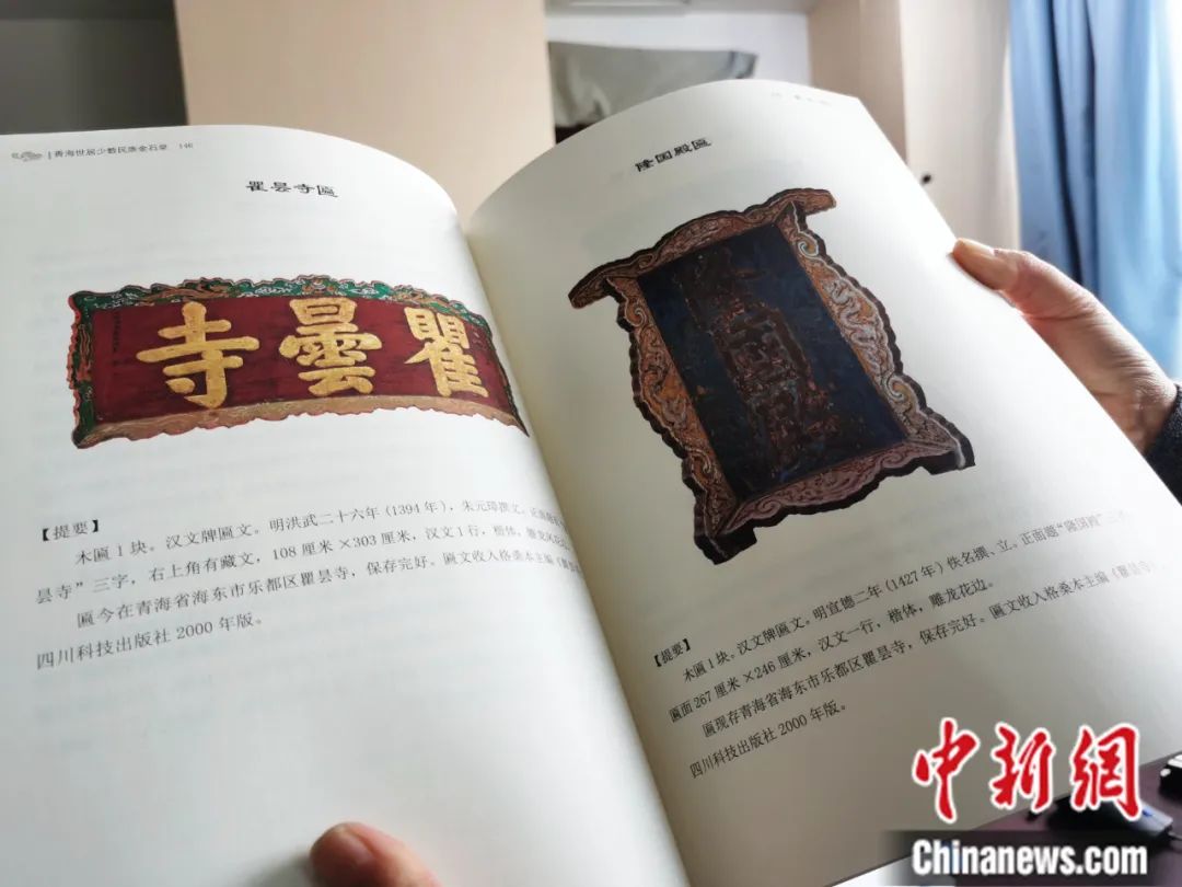 古籍保護人員展示介紹明代朱元璋撰寫的青海瞿曇寺匾(左)的出版書籍。張?zhí)砀?攝