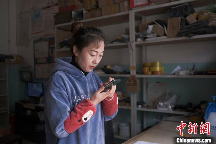 正在快遞站點內(nèi)忙碌的楊莉春?！『闻罾?攝