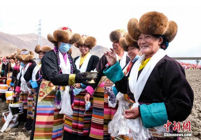 資料圖：西藏自治區(qū)拉薩市曲水縣才納鄉(xiāng)協(xié)榮村參加春耕儀式的村民互敬青稞酒。按照傳統(tǒng)，當(dāng)?shù)卮迕裆碇?jié)日盛裝，舉行隆重的儀式，祈福一年的豐收。<a target='_blank' ><p  align=