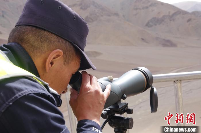 索朗曲扎用望遠(yuǎn)鏡查看邊境情況。　冉文娟 攝