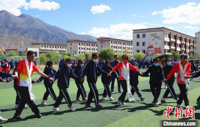 圖為世界冠軍與拉薩阿里地區(qū)高級(jí)中學(xué)學(xué)生一起跳鍋莊?！∪轿木?攝