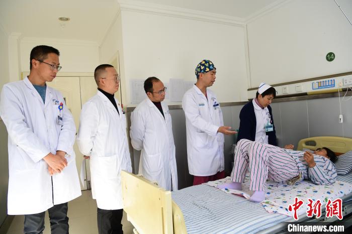 圖為何蔚副主任醫(yī)師(站右二)及團隊術后指導患者進行腰背肌鍛煉?！∝暩聛硭?攝