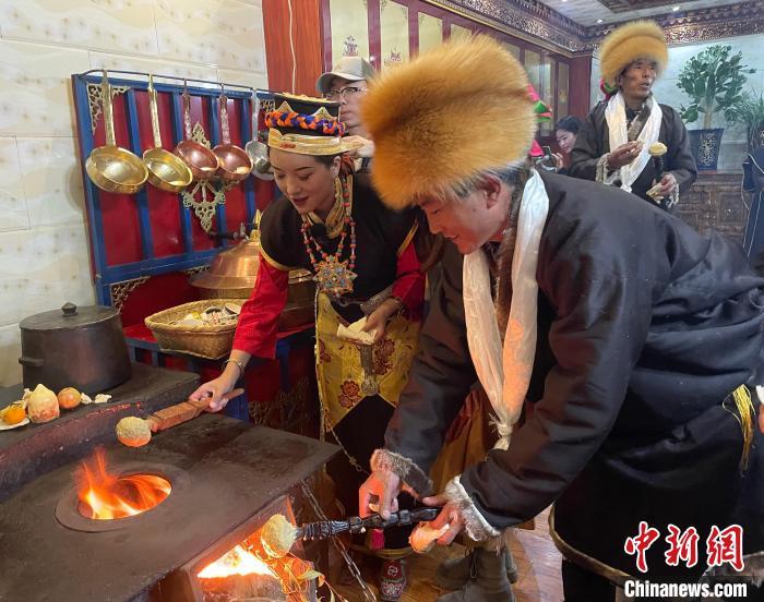 圖為人們在火上烤節(jié)日美食“結(jié)達”。　冉文娟 攝