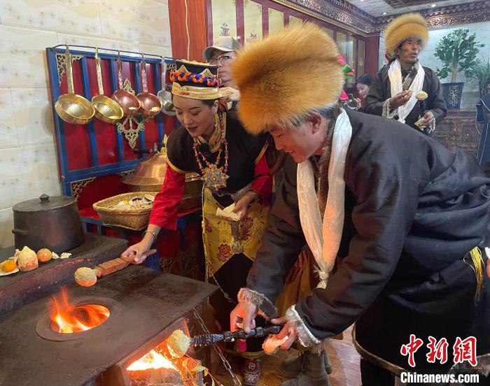 圖為人們?cè)诨鹕峡竟?jié)日美食“結(jié)達(dá)”。　冉文娟 攝