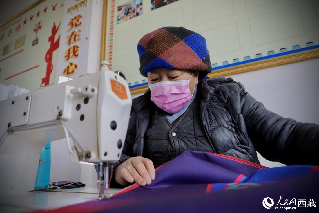 農(nóng)牧民專業(yè)合作社里的村民正在制作門簾。人民網(wǎng) 次仁羅布攝