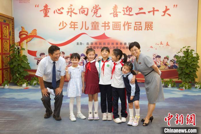 圖為與會嘉賓與入選畫作的“小作者”們在展覽上合影。　中國藏學研究中心供圖