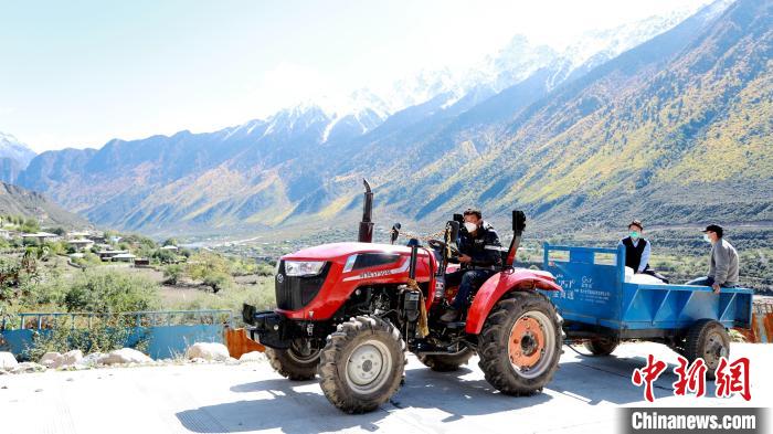 圖為工作人員將把加工完成的糌粑運(yùn)送至村民手中。　嘉黎縣融媒體中心供圖