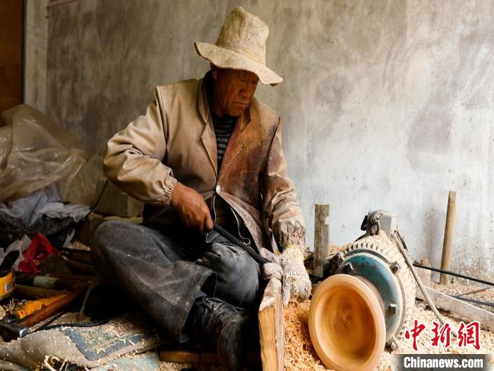 圖為手工藝人正在制作木碗?！?鄧海平 攝