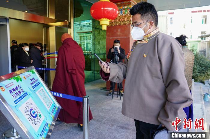 圖為政協委員掃場所碼進入會場?！〗w波 攝