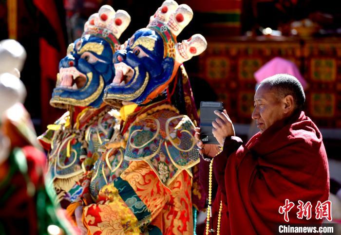 2月19日，正在拍攝跳神活動(dòng)的僧人?！±盍?攝