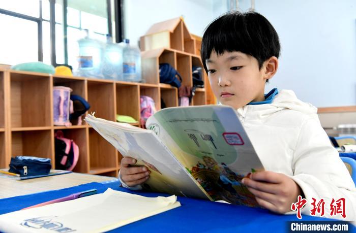 3月14日，西藏拉薩市第一小學(xué)一年級六班學(xué)生丁增樂吉在閱讀藏語課本。　李林 攝